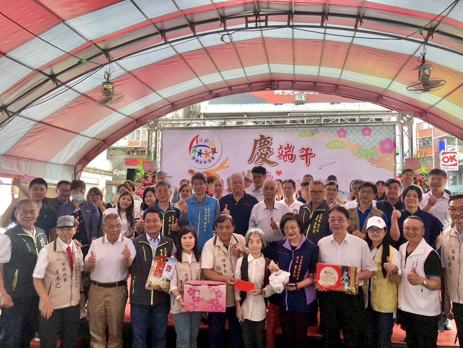 淡水區關懷弱勢協會24日在淡水老街廣場舉辦「慶端午 送愛心」活動,發放弱勢家戶關懷金及物資,並頒發清寒學子獎助學金